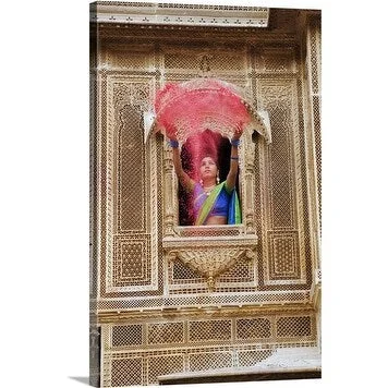 Premium Thick-Wrap Canvas entitled Woman throwing brightly colored holi powder through a window of a haveli.